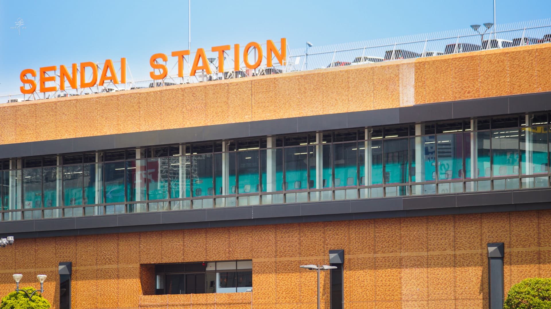 Sendai Station facade with a Shinkansen visible through the windows